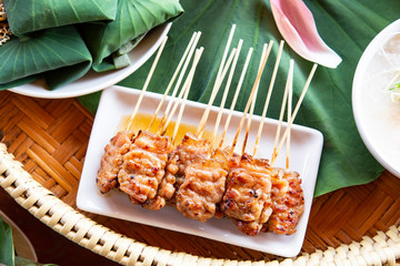 Grilled pork with sweet spicy sauce on asian decoration table.