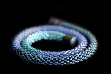 Beaded necklace three shades of blue on a dark background close up