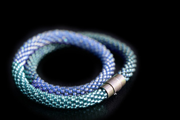 Beaded necklace three shades of blue on a dark background close up