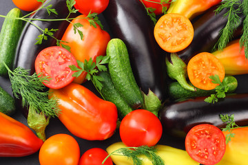 Assortment of fresh raw vegetables on black background. Tomato, eggplant, onion, pepper, parsley, spices. Top view