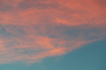 Teal and orange cloudy sky background.