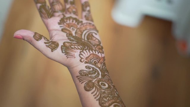 Beautiful henna or mehendi decoration on a hindu bride's hand by a henna artist