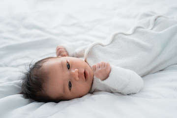 cute little infant newborn baby on white bed