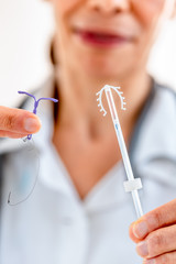 Female doctor holding two knd of intra utreine devine for birth control IUD