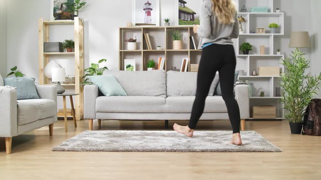 Young girl with a phone on a sofa in a cozy living room