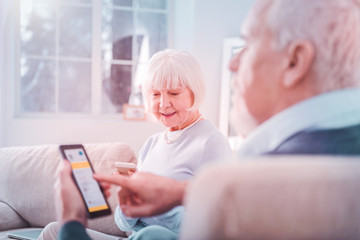 Fototapeta premium Beautiful grey-haired wife sitting near her bearded retired husband