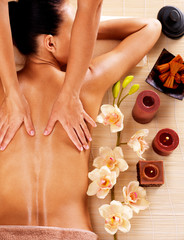 Masseur doing massage on woman back in spa salon
