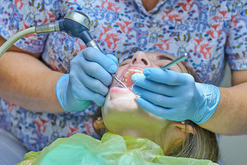 Close up photo of process of professional cleanng teeth.