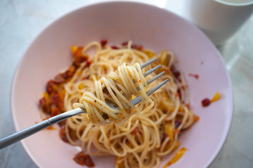 Spaghetti on fork. Italian pasta with herbs and spices, close-up, vegetarian recipe. Concept eating at home.