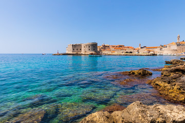 Fototapeta na wymiar Historical city walls of Dubrovnik seen from a nearby beach