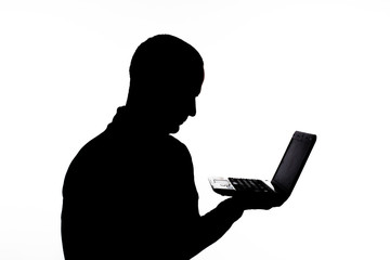 silhouette: guy on a white background holds a netbook in hands
