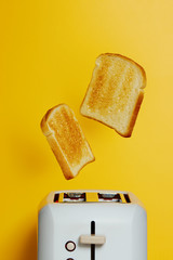 Slices of toast jumping out of the toaster - obrazy, fototapety, plakaty