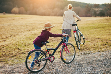 Fototapeta premium Mother and daughter with bicycles on countryside.