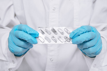 Scientist biotechnologist in blue gloves holds in his hands an experimental medical product