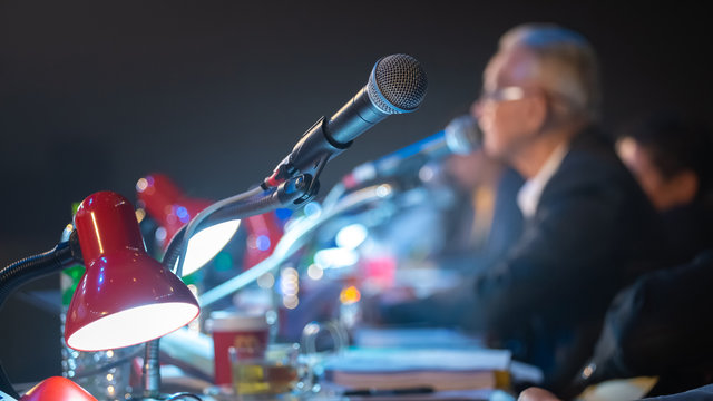 Business People Talking On Seminar Panel With Microphone