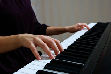 Fototapeta premium Young woman playing piano