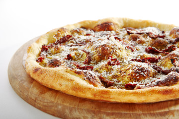 Hot Crispy Focaccia with Pesto Sauce, Mozzarella, Grated Parmesan Cheese, Butter, Greens, Basil Oil, and Dried Tomatoes on Wooden Plate Top View. Fresh Italian Bread Tortilla Isolated