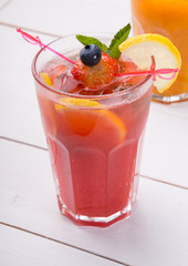 Glass of red juice with ice and strawberry