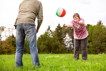 Geistig behinderte Frau spielt mit einem Ball, Geschicklichkeit und Konzentration durch Spiele