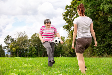 Geistig behinderte Frau spielt Fussball mit einer Pflegerin spielen gemeinsam Ball