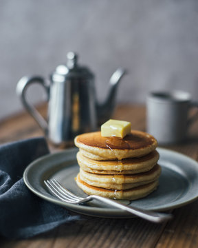 Stack of pancakes with butter and honey on top