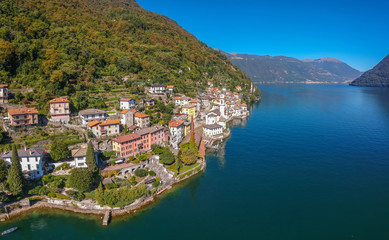 Fototapeta na wymiar Aerial view landscape on beatiful Lake Como in Lombardy, Italy. Scenic small town with traditional houses and clear blue water. Summer tourist vacation on rich resort with nice harbour