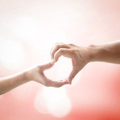 Corporate social responsibility (CSR) concept: Two human hands forming in shape of heart over blurred nature background
