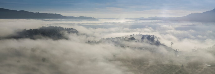 Mountain view panorama 180 degree morning of top hills and forest in valley around with sea of fog with cloudy sky background, sunrise at Khao Takhian Ngo (Takian Ngo), Khao Kho, Phetchabun, Thailand.