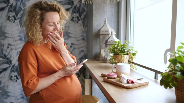Pregnant Woman Using Smartphone. Young Expectant Lady Surfing Net In Cafe.