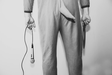 Man in cosplay costume of a cow singing karaoke. Guy in the funny animal pyjamas sleepwear holding...