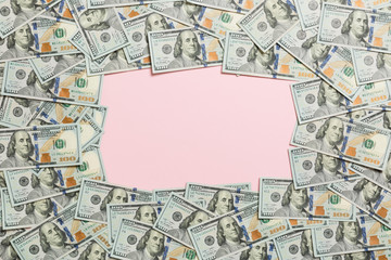 Frame made of dollars with copy space in the middle. Top view of business concept on pink background with copy space