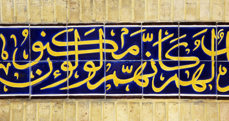 Mosque tiled brick wall with arabic calligraphy 