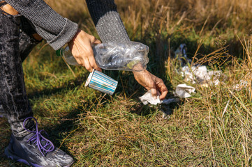 Hand woman picking up plastic bottle cleaning in the street, in forest, volunteer concept