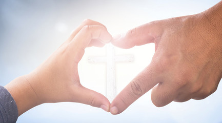 Love Jesus concept: Heart shape of father and son hands with cross