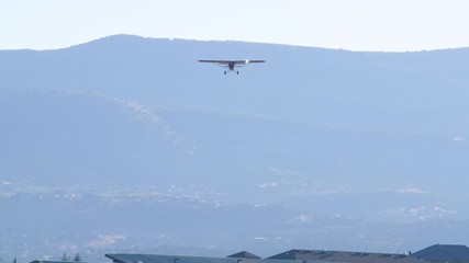 Carbon Cub monoplane with the lights is descending hand held shot. Aerial shot of a light civilian aircraft preparing for the take off from the runway of Heber City airport.