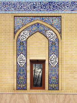 Mosque wall with Arabic calligraphy on decorative mosaic tiles 