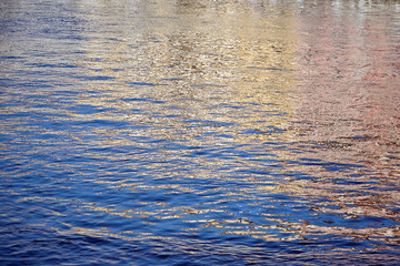 Colorful ripples on the water surface. Reflections in the river