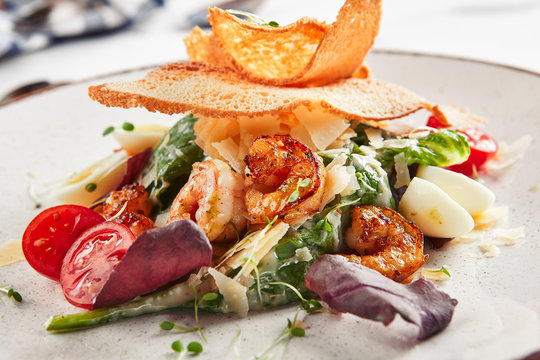 Beautiful serving white restaurant plate of caesar salad