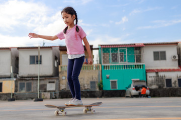 Asian little girl playing skateboard select focus shallow depth of field