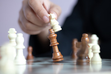 Close up shot hand of business woman playing the chess board to win by killing the king of opponent metaphor business competition winner and loser select focus shallow depth of field