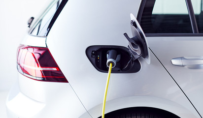 Close Up Of Power Cable Charging Environmentally Friendly Zero Emission Electric Car In Garage