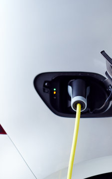 Close Up Of Power Cable Charging Environmentally Friendly Zero Emission Electric Car In Garage