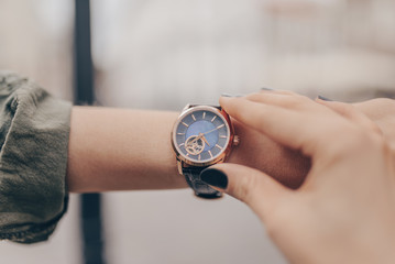 Stylish golden watch on woman hand