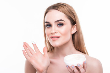 Obraz na płótnie Canvas Young woman applying face cream on perfect skin, isolated on white background