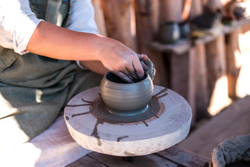 Potter is creating earthenware on potter's wheel.