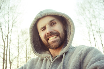 cheerful man with  smile,  bearded guy looks at the camera and laughs, a bright spring smile of a man