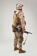 Studio shoot of modern infantry soldier, U.S. marine rifleman in combat uniform, helmet and body armor