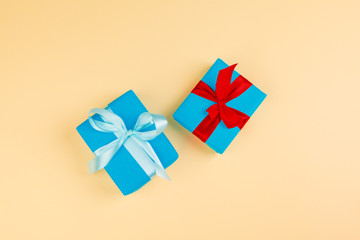 Decorated colored present on yellow background flatlay