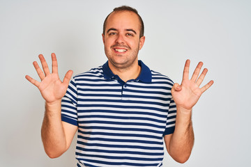 Naklejka premium Young man wearing casual striped polo standing over isolated white background showing and pointing up with fingers number nine while smiling confident and happy.
