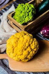 Chou-fleur jaune aubergine courgette chou romanesco sur une planche à découper, légumes bio du jardin